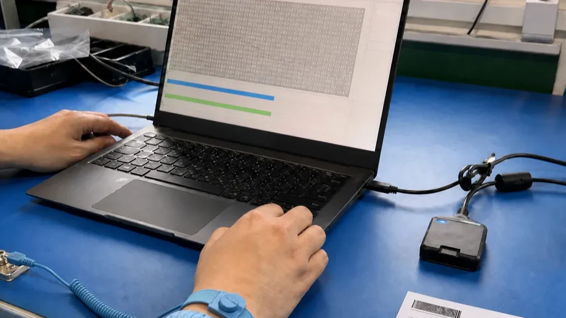 Factory quality workstation running a controlled microSD write and readback verification through a dedicated card reader